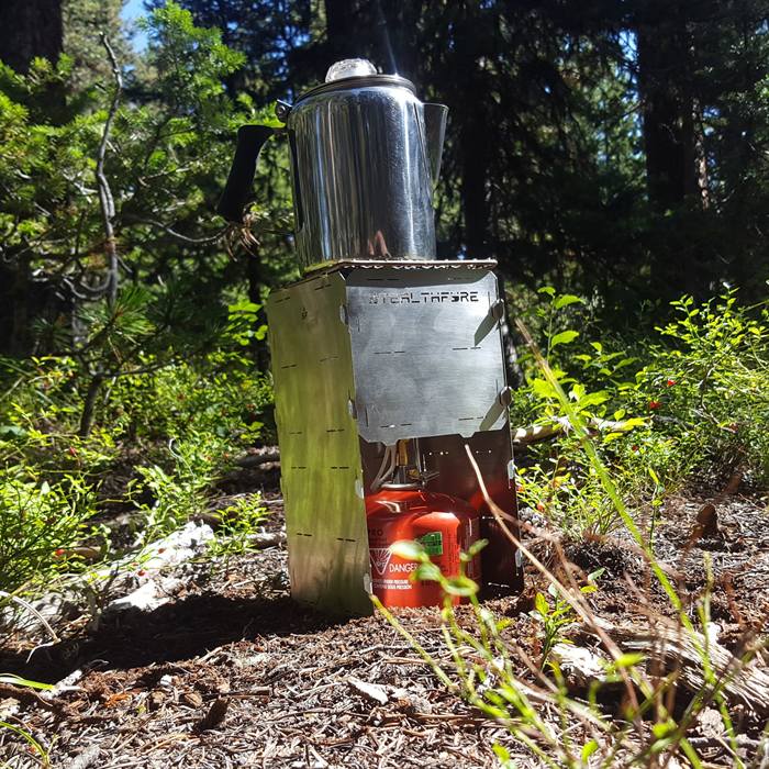 A percolator heating on a StealthFyre panel stove, brand name visible stamped on the stainless face