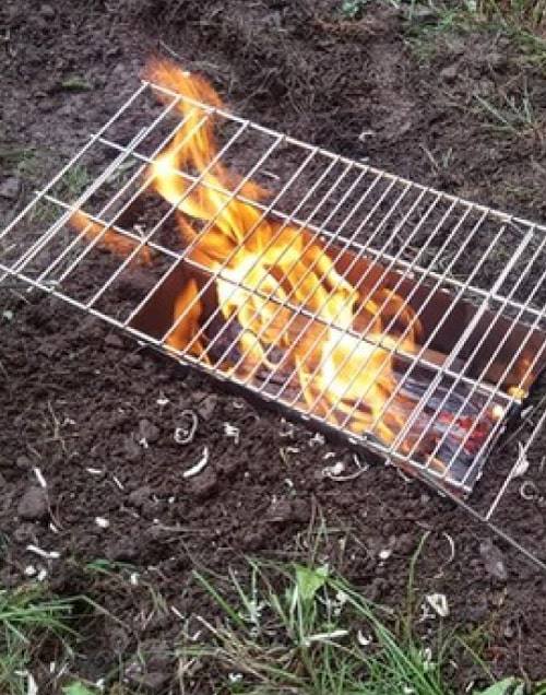 A StealthFyre stove assembled and burning in a forest camp